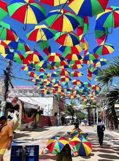 Rua coberta por guarda-sóis coloridos